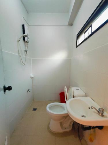 a bathroom with a toilet and a sink at Bogah Lodge in Banaue