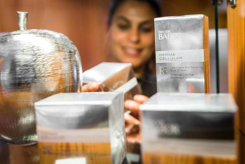 a woman standing behind a counter with boxes of soap at Hotel Angelo Engel in Ortisei