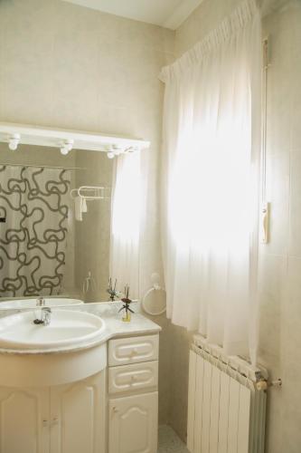 a white bathroom with a sink and a mirror at Señorío de Ves in Casas de Ves