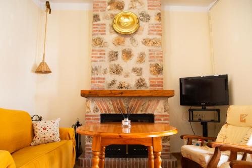 a living room with a table and a fireplace at Señorío de Ves in Casas de Ves