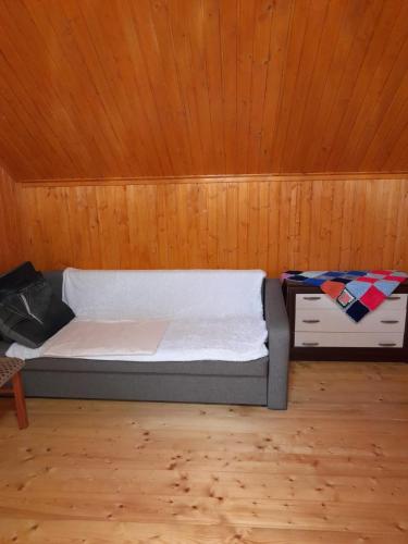 a bed in a room with a wooden ceiling at соколів камінь in Novoselitsa