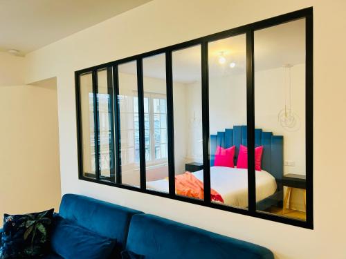 a mirror on a wall above a couch in a room at Reims Cathédrale / Hyper Centre in Reims