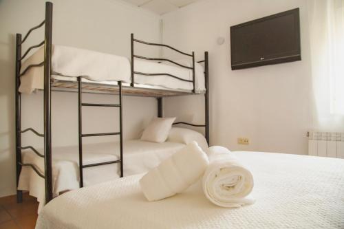 a bedroom with two bunk beds and a flat screen tv at Señorío de Ves in Casas de Ves