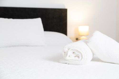 a white bed with a rolled up towel on it at Señorío de Ves in Casas de Ves