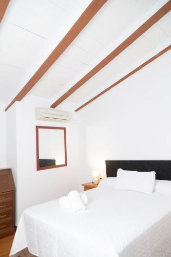a white bedroom with two beds and a window at Señorío de Ves in Casas de Ves