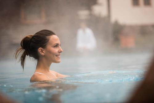 a woman swimming in a swimming pool at Hotel Angelo Engel in Ortisei