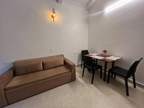 a living room with a couch and a table at Modern 1BHK AC Apartment 500m to Cavelossim beach-Bonita in Cavelossim