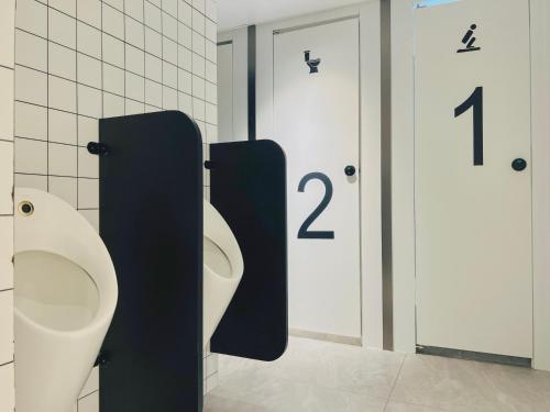 two urinals in a bathroom with numbers on the wall at Dayin Garden Hotel -People's Square & Nanjing Road-Large Social Area -Bar -Café -Gym -Free Laundry Luggage Storage -24H Front Desk-English Service in Shanghai