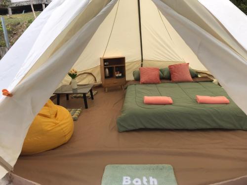 a bedroom in a tent with a bed and a table at Hangout Khaokho รีสอร์ต G1 in Khao Kho
