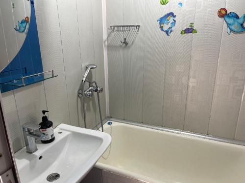 a bathroom with a sink and a shower and a tub at Апартамент зал спальня кухня in Yunusobod