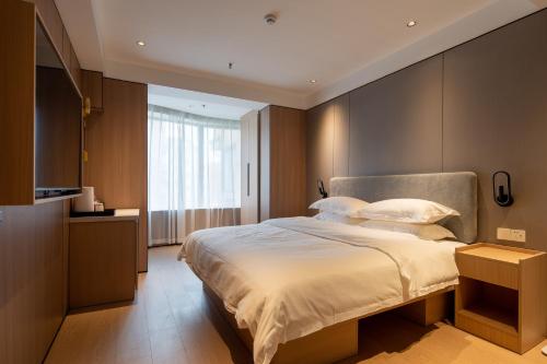 a bedroom with a large bed and a large window at Dayin Garden Hotel -People's Square & Nanjing Road-Large Social Area -Bar -Café -Gym -Free Laundry Luggage Storage -24H Front Desk-English Service in Shanghai