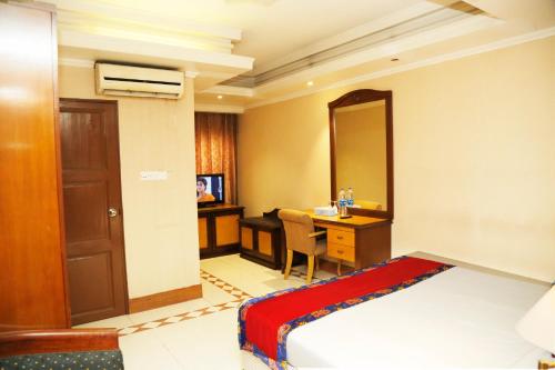 a hotel room with a bed and a desk and a mirror at Sea Shell Residence - Dhaka in Dhaka