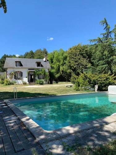 une grande piscine devant une maison dans l'établissement Maison de campagne avec piscine et étang, à Villegenon