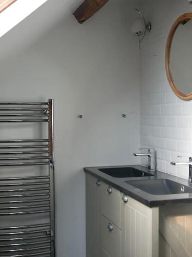 une salle de bain avec un lavabo et un miroir dans l'établissement Maison de campagne avec piscine et étang, à Villegenon