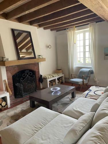 un salon avec un canapé et une cheminée dans l'établissement Maison de campagne avec piscine et étang, à Villegenon