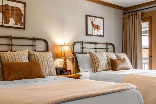 a bedroom with two beds and a table with a lamp at Sierra Sky Ranch in Oakhurst