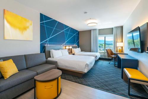 a hotel room with a bed and a couch at Comfort Suites Kelowna in Kelowna