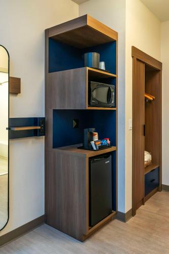 a kitchen with a shelf with a microwave in a room at Comfort Suites Kelowna in Kelowna