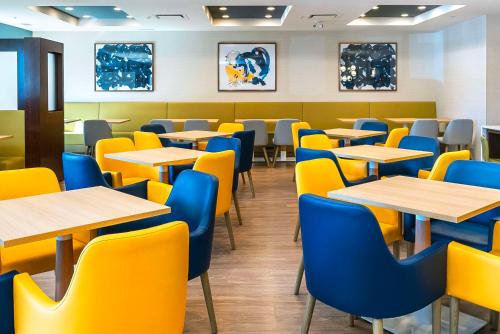 a dining room with tables and yellow chairs at Comfort Suites Kelowna in Kelowna