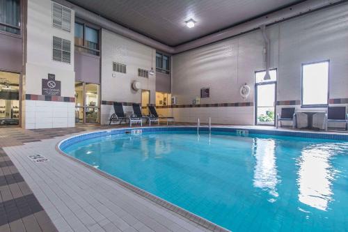 a large swimming pool in a hotel with chairs and tables at Quattro Hotel & Conf Centre, an Ascend Collection Hotel in Sault Ste. Marie