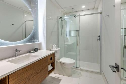 a bathroom with a shower and a toilet and a sink at Hotel Royal William, an Ascend Collection Hotel in Quebec City