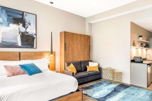 a bedroom with a bed and a couch at Hotel Royal William, an Ascend Collection Hotel in Quebec City