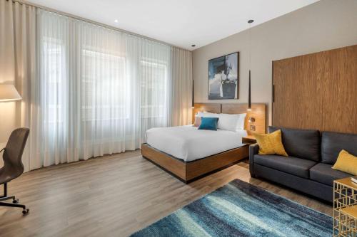 a hotel room with a bed and a couch at Hotel Royal William, an Ascend Collection Hotel in Quebec City
