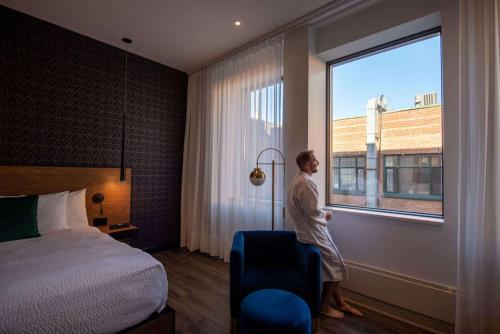 a man standing in a hotel room looking out the window at Hotel Royal William, an Ascend Collection Hotel in Quebec City