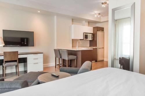 a room with a kitchen and a living room at Les Suites Victoria, an Ascend Collection Hotel in Gatineau