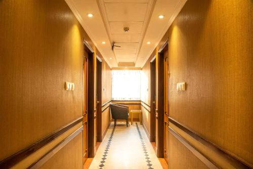 a hallway with a chair and a window in a building at Sea Shell Residence - Dhaka in Dhaka