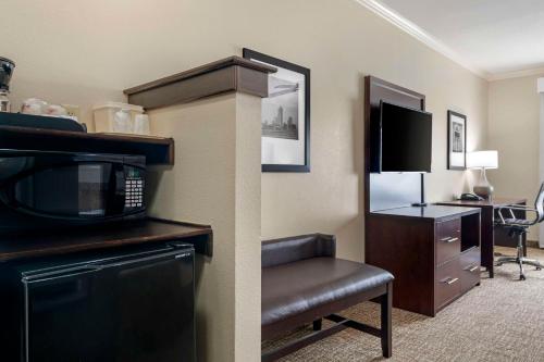 a hotel room with a microwave and a chair at Comfort Inn & Suites Fort Worth - Fossil Creek in Fort Worth