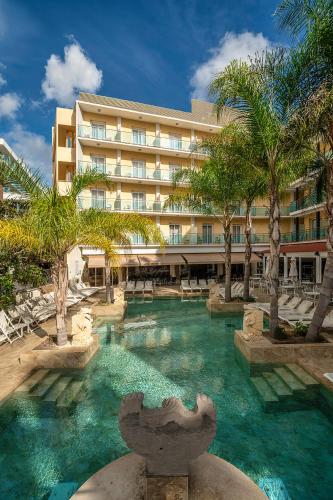 a pool in front of a hotel at Hotel la Palmera & Spa in Lloret de Mar