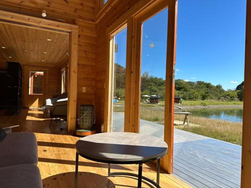 a cabin with a porch with a view of a lake at Cozmo in Nikko
