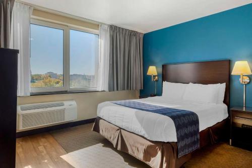 a hotel room with a bed and a large window at The Capitol Hotel in Hartford