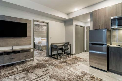 a hotel room with a desk and a tv and a bed at The Hue Hotel, an Ascend Collection Hotel in Kamloops