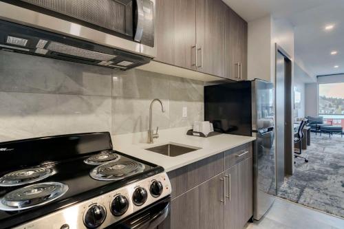 a kitchen with a stove and a sink at The Hue Hotel, an Ascend Collection Hotel in Kamloops