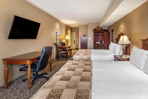 a hotel room with two beds and a desk at The Parlour Inn, an Ascend Collection Hotel in Stratford