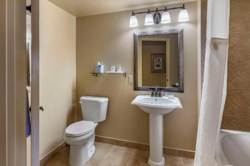 a bathroom with a toilet and a sink and a mirror at The Parlour Inn, an Ascend Collection Hotel in Stratford