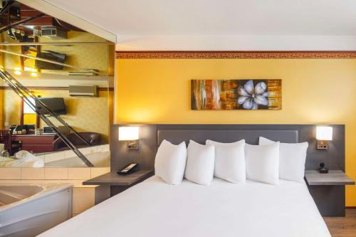 a hotel room with a bed and a bath tub at Les Suites de Laviolette, an Ascend Collection Hotel in Trois-Rivières
