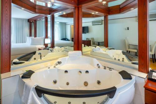 a large bathroom with a tub and a large mirror at Les Suites de Laviolette, an Ascend Collection Hotel in Trois-Rivières