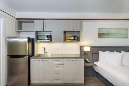 a small kitchen with a sink and a refrigerator at Les Suites de Laviolette, an Ascend Collection Hotel in Trois-Rivières