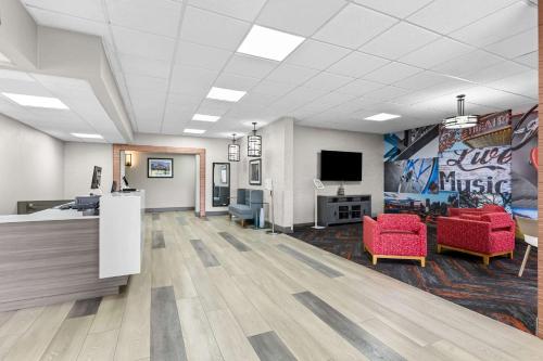 an office with a waiting room with red chairs and a tv at Clarion Pointe Franklin - Nashville Area in Franklin