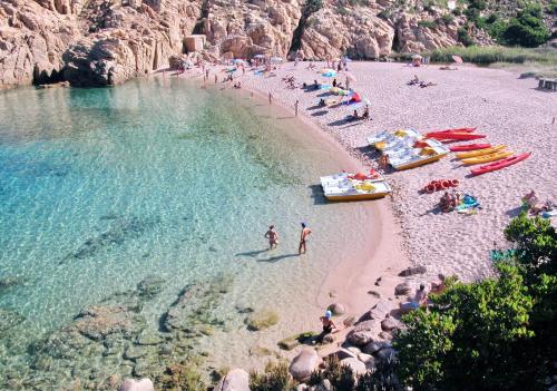 a group of people on a beach in the water at ISA-Residence with swimming-pool in Costa Paradiso, apartments 6 beds with private outdoor area in Costa Paradiso