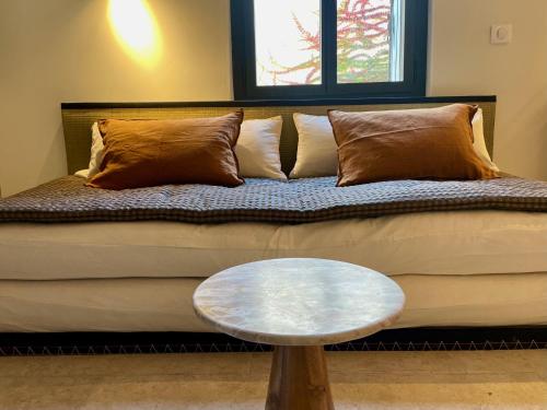 a couch with pillows and a table in a room at "La Forge" avec parking privé in Sète