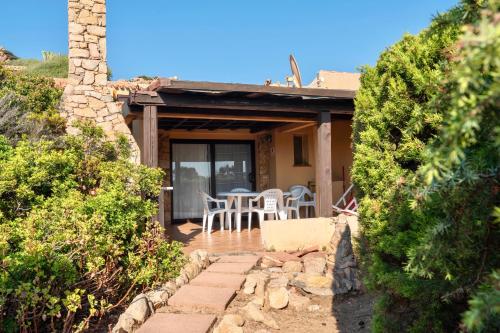 a house with a patio with a table and chairs at ISA-Residence with swimming-pool in Costa Paradiso, apartments 6 beds with private outdoor area in Costa Paradiso