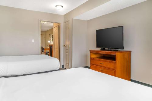 a bedroom with two beds and a flat screen tv at Country Inn & Suites by Radisson, Rossford - Toledo South in Rossford