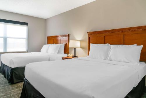 a hotel room with two beds and a window at Country Inn & Suites by Radisson, Rossford - Toledo South in Rossford
