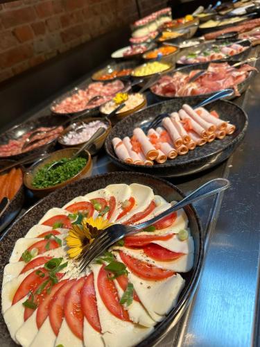 a buffet of different types of food on plates at B&B Herenhuis in Izegem