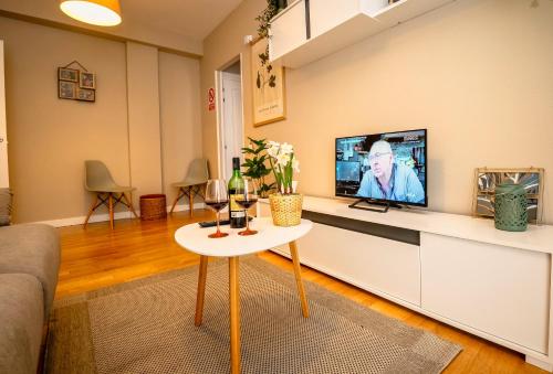 a living room with a tv and a table at Santiago Tower Aire Ac casco antiguo By Apartamentos Logrono in Logroño