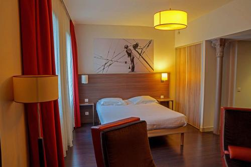 a hotel room with a bed and a red curtain at Comfort Aparthotel Saint-Etienne in Saint-Étienne